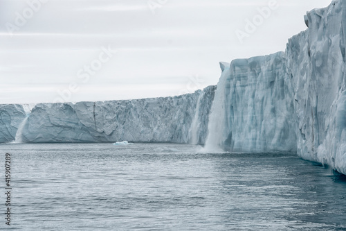 Svalbard, Nordaustlandet Island. Waterfalls cascade from the melting glacier.
