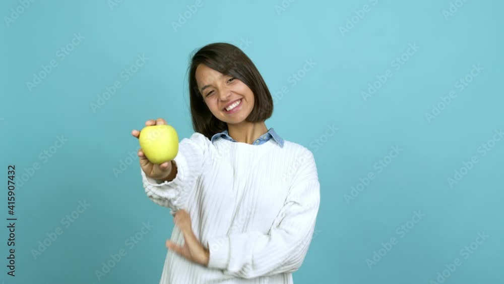 Young brunette woman holding an apple over isolated background Young brunette woman holding an apple over isolated background