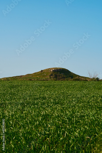 Ta' Dbiegi hill over a field in Gozo, Malta