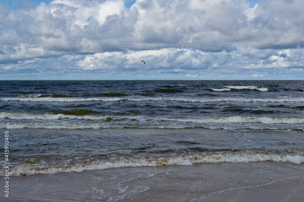 Beach during the day. Clouds and sea waves.