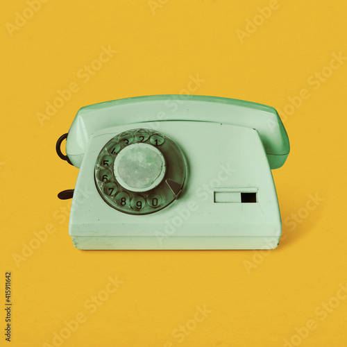 Retro vintage rotary telephone isolated on yellow background pop art