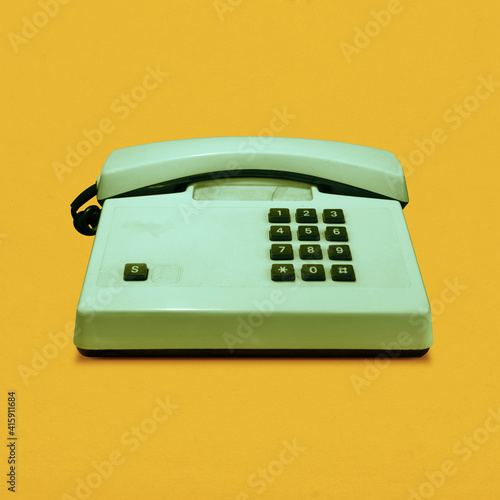 Retro vintage push-button telephone isolated on yellow background pop art
