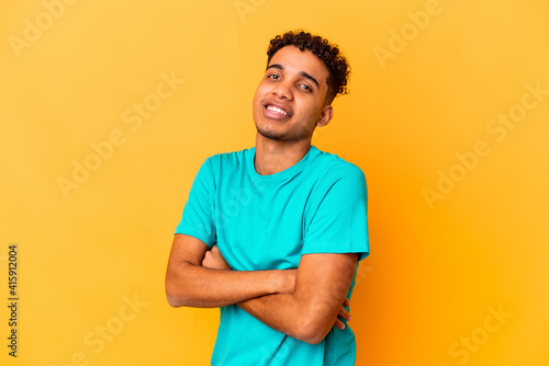 Young african american curly man isolated on purple who feels confident, crossing arms with determination.