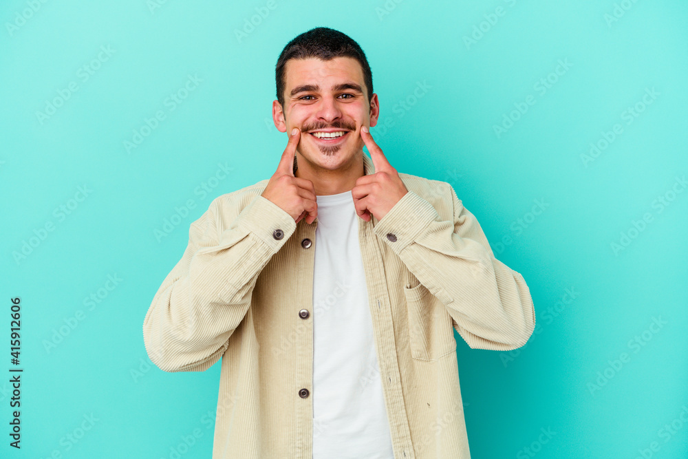 Young caucasian man isolated on blue background doubting between two options. Young caucasian man isolated on blue background doubting between two options.