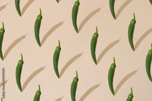 Fresh green chili peppers pattern on pastel beige background. minimal creative food concept.