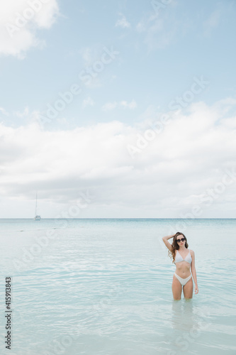 Relaxed woman enjoying sun, freedom and life an beautiful beach in sunset. Young lady feeling free, relaxed and happy. Concept of vacations, freedom, happiness, enjoyment and well being. © ALEXSTUDIO