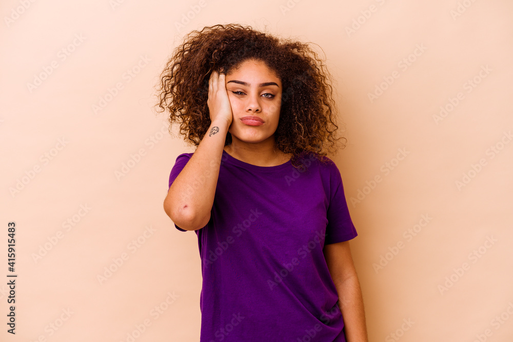Young african american woman isolated on beige background tired and very sleepy keeping hand on head. Young african american woman isolated on beige background tired and very sleepy keeping hand on head.