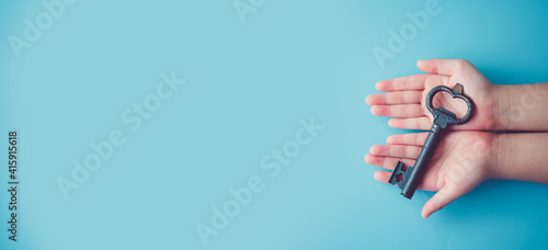Unlock brain potential in kid.Child girl hands holding Key.Key for safety, Lock, Unlock, Security, secret, DNA, Success, Entrance, Protect kid and children.Child development education.Child rights.crc