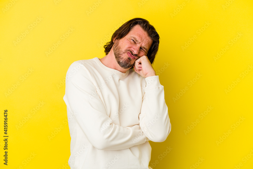 Middle age caucasian man isolated on yellow background tired of a repetitive task. Middle age caucasian man isolated on yellow background tired of a repetitive task.