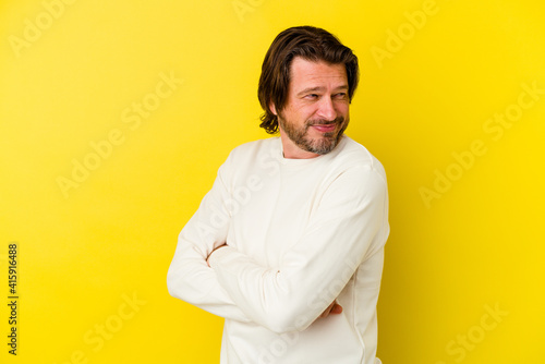 Middle age caucasian man isolated on yellow background laughing and having fun.