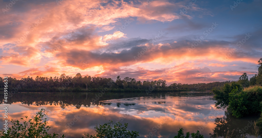 Panoramic Riverside Sunrise with Dramatic Cloud Reflections