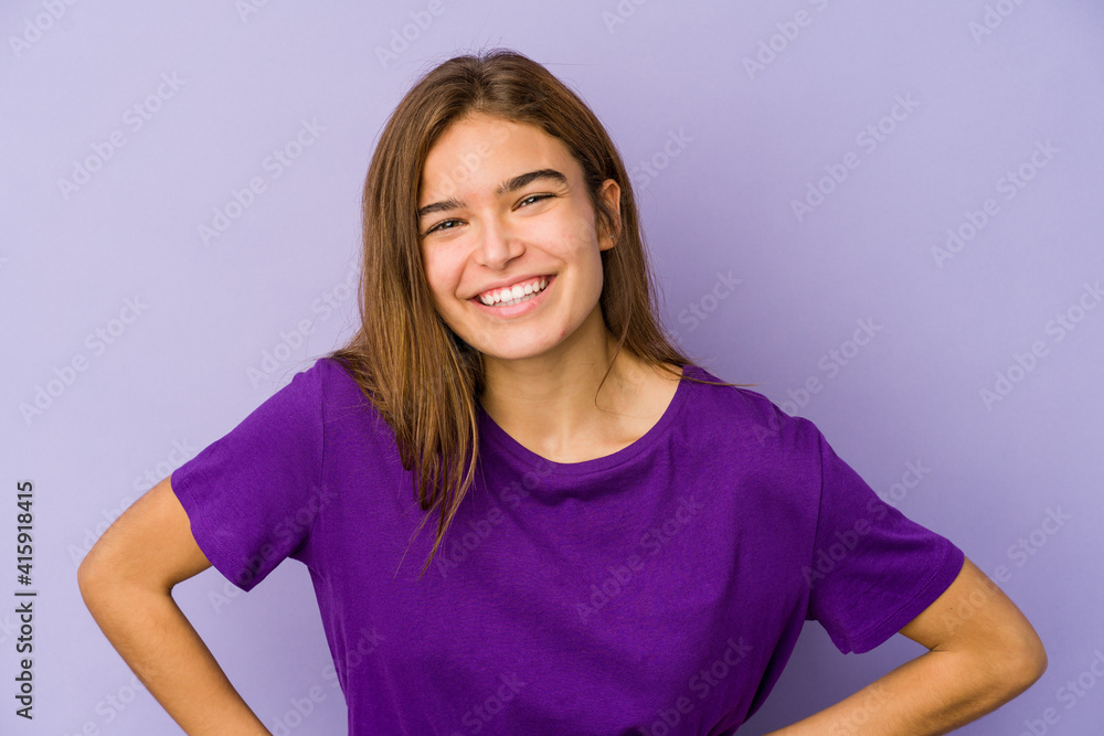 Young skinny caucasian girl teenager on purple background confident keeping hands on hips. Young skinny caucasian girl teenager on purple background confident keeping hands on hips.
