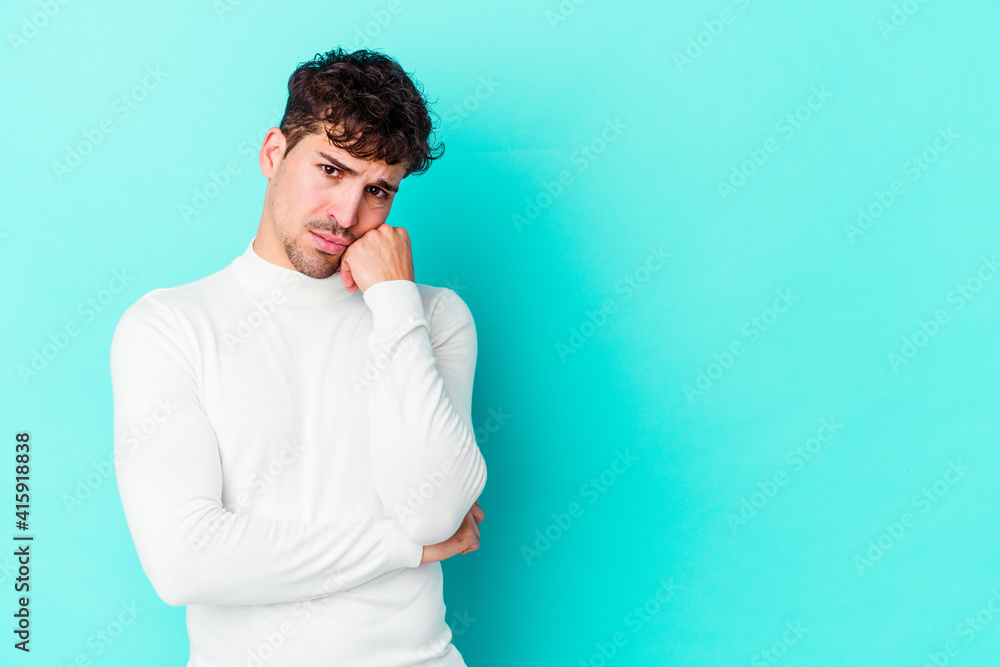 Young caucasian man isolated on blue background who feels sad and pensive, looking at copy space. Young caucasian man isolated on blue background who feels sad and pensive, looking at copy space.