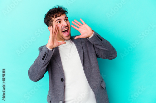 Schilderij op canvas Young caucasian man isolated on blue background shouting excited to front