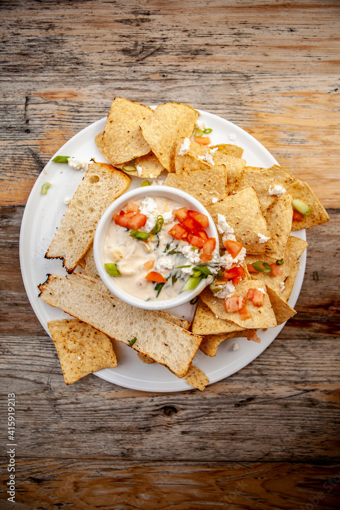 Yummy Quesadilla Dip with Bread and Chips and fresh Herbs and Tomatoes