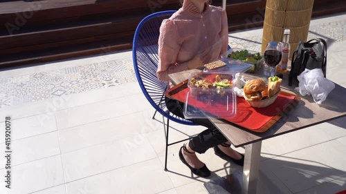 Beautiful business woman enjoys lunch break on a rootop wearing victoria shirt photo