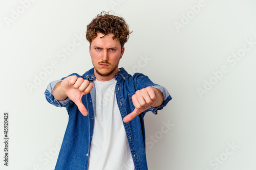 Young caucasian man isolated on white background showing a dislike gesture, thumbs down. Disagreement concept.