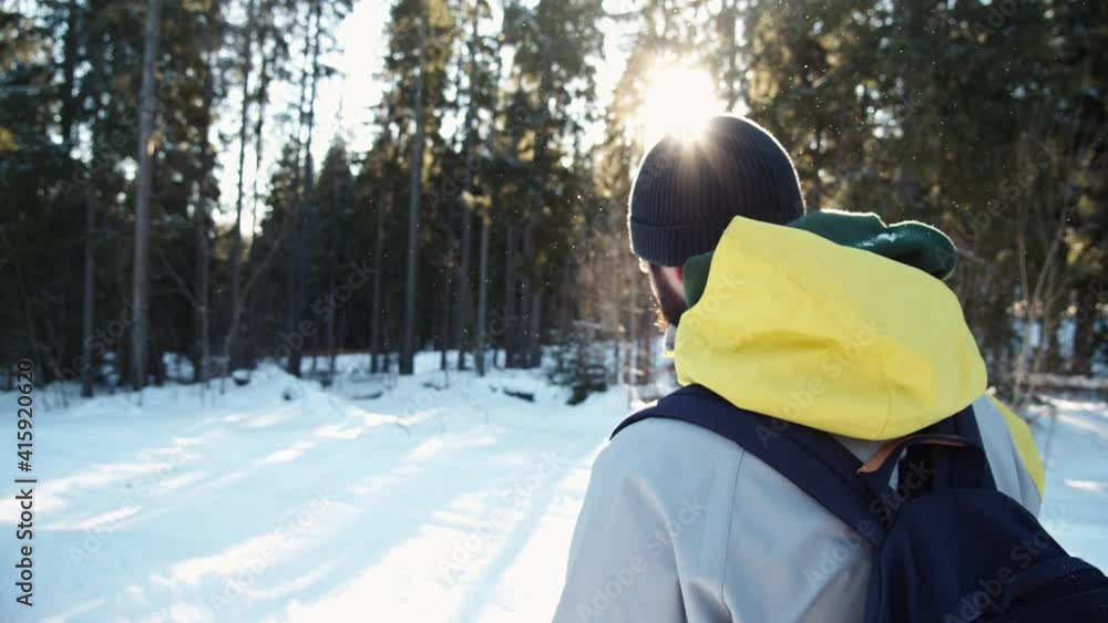 Bearded tourist man in warm winter clothes walking through snowy forest on sunny day. Outdoor portrait. Winter adventures. Bearded tourist man in warm winter clothes walking through snowy forest on sunny day. Outdoor portrait. Winter adventures.