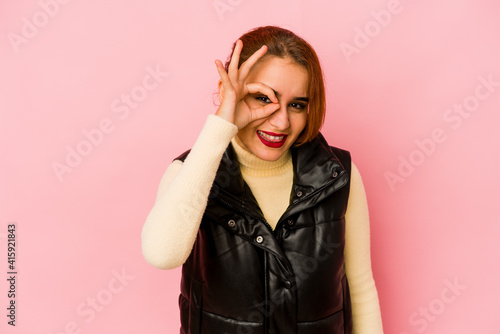 Young arab mixed race woman excited keeping ok gesture on eye. © Asier