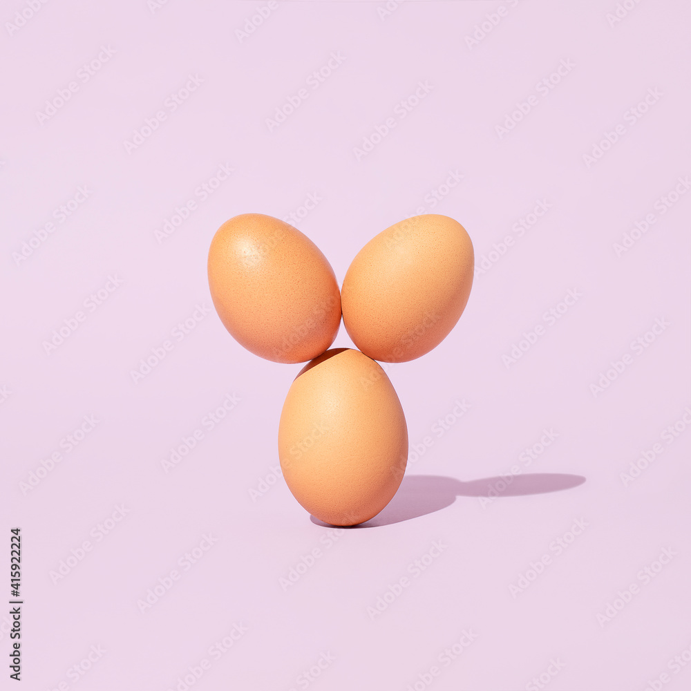 Easter eggs arranged like they have bunny ears on purple background. Minimal spring holiday concept. Easter eggs arranged like they have bunny ears on purple background. Minimal spring holiday concept.