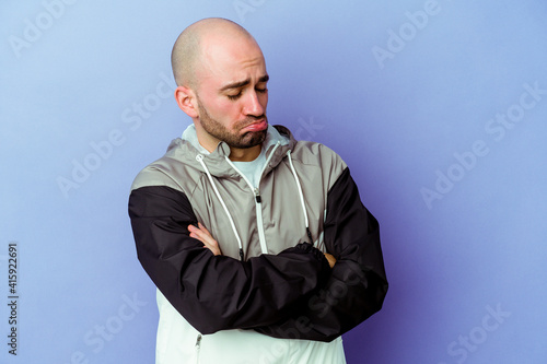 Young caucasian bald man isolated on purple background tired of a repetitive task.