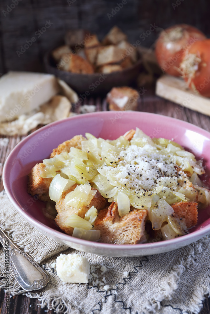 Italian Cuisine. Roman onion soup with toast bread and grated cheese Italian Cuisine. Roman onion soup with toast bread and grated cheese