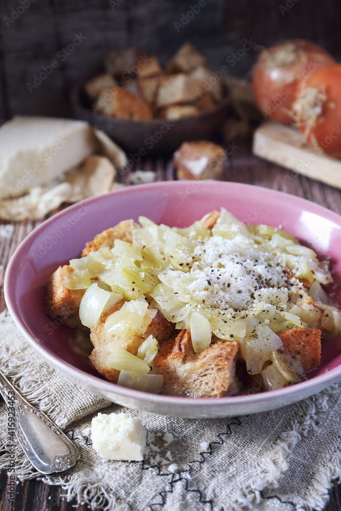 Italian Cuisine. Roman onion soup with toast bread and grated cheese