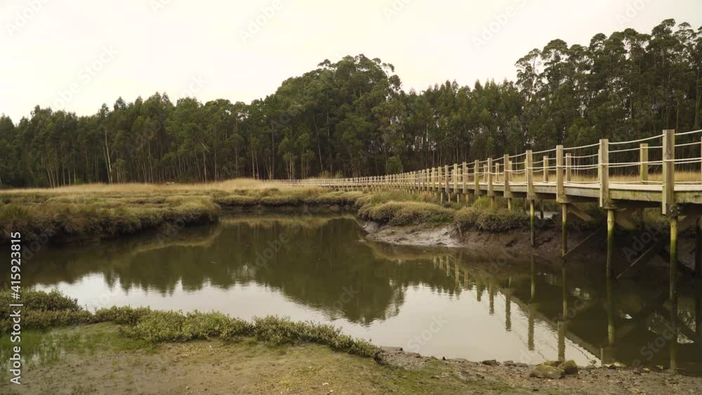 4K wooden food path over a low tide pond in the Ria de Aveiro on the estuary of the river Vouga. 4K wooden food path over a low tide pond in the Ria de Aveiro on the estuary of the river Vouga.