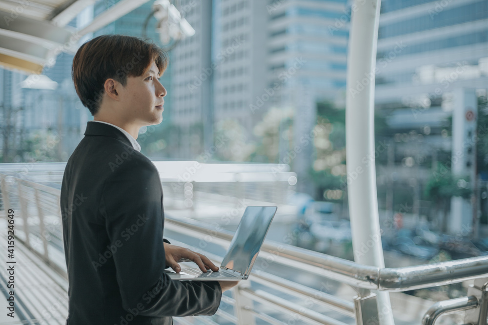 Asian businessman using laptop outdoor. Asian businessman using laptop outdoor.