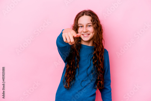 Little caucasian girl isolated on pink background cheerful smiles pointing to front.