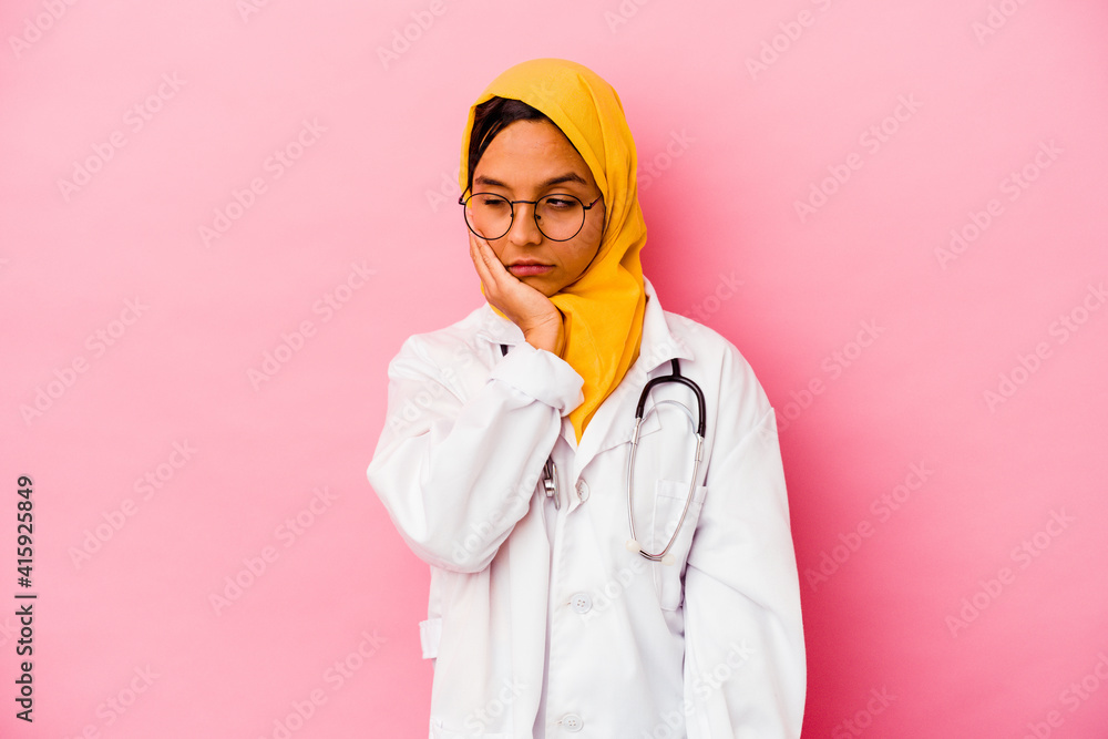 Young doctor muslim woman isolated on pink background who is bored, fatigued and need a relax day. Young doctor muslim woman isolated on pink background who is bored, fatigued and need a relax day.