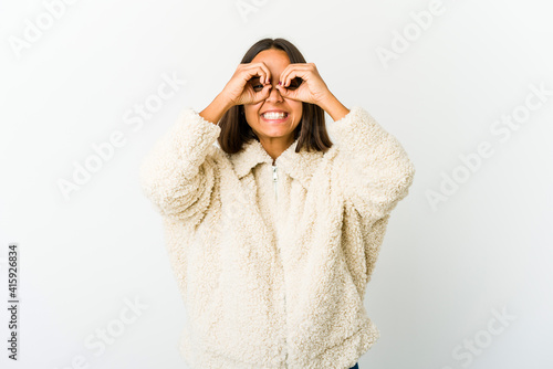 Young mixed race woman showing okay sign over eyes