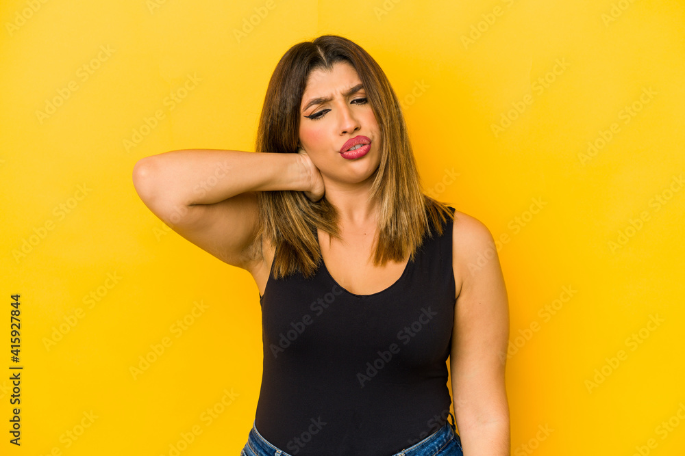 Young indian woman isolated on yellow background suffering neck pain due to sedentary lifestyle. Young indian woman isolated on yellow background suffering neck pain due to sedentary lifestyle.