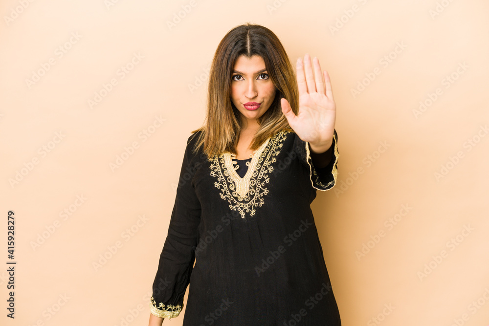 Young indian woman wearing traditional clothes isolated standing with outstretched hand showing stop sign, preventing you. Young indian woman wearing traditional clothes isolated standing with outstretched hand showing stop sign, preventing you.