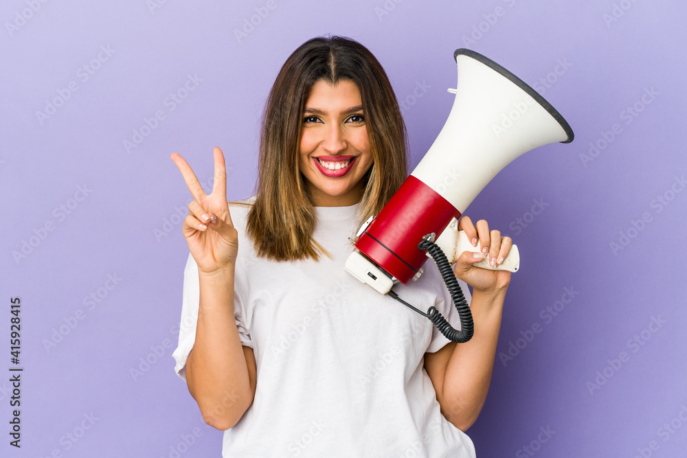 Young indian woman holding a megaphone isolated showing number two with fingers. Young indian woman holding a megaphone isolated showing number two with fingers.
