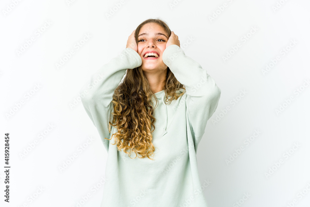 Young caucasian woman laughs joyfully keeping hands on head. Happiness concept. Young caucasian woman laughs joyfully keeping hands on head. Happiness concept.