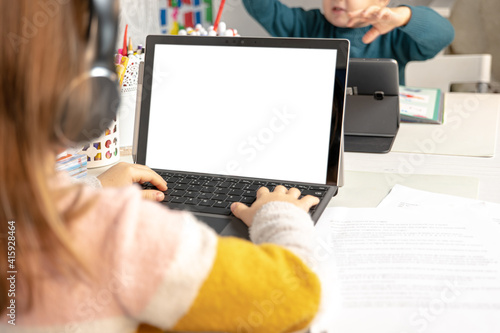 online training. the girl sits at the computer in the room and does her homework