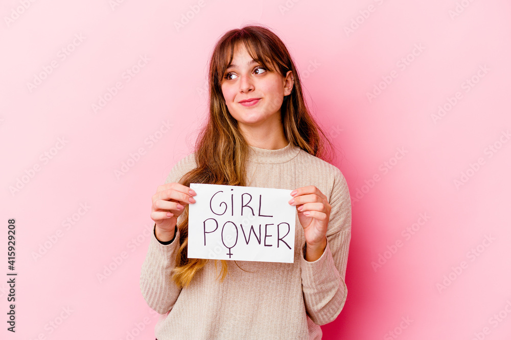 Young caucasian woman holding a girl power placard isolated on pink background dreaming of achieving goals and purposes Young caucasian woman holding a girl power placard isolated on pink background dreaming of achieving goals and purposes