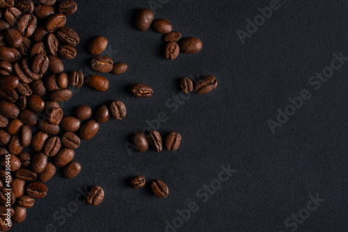 Fresh roasted coffee beans closeup on black stone background. Top view  flat lay with copy space