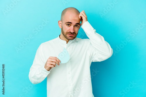 Young caucasian bald man celebrating world water day isolated on blue background being shocked, she has remembered important meeting.