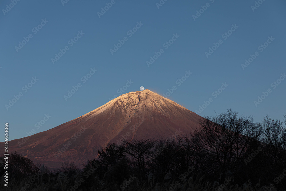 Fototapeta premium 富士山の頂上から月が出た