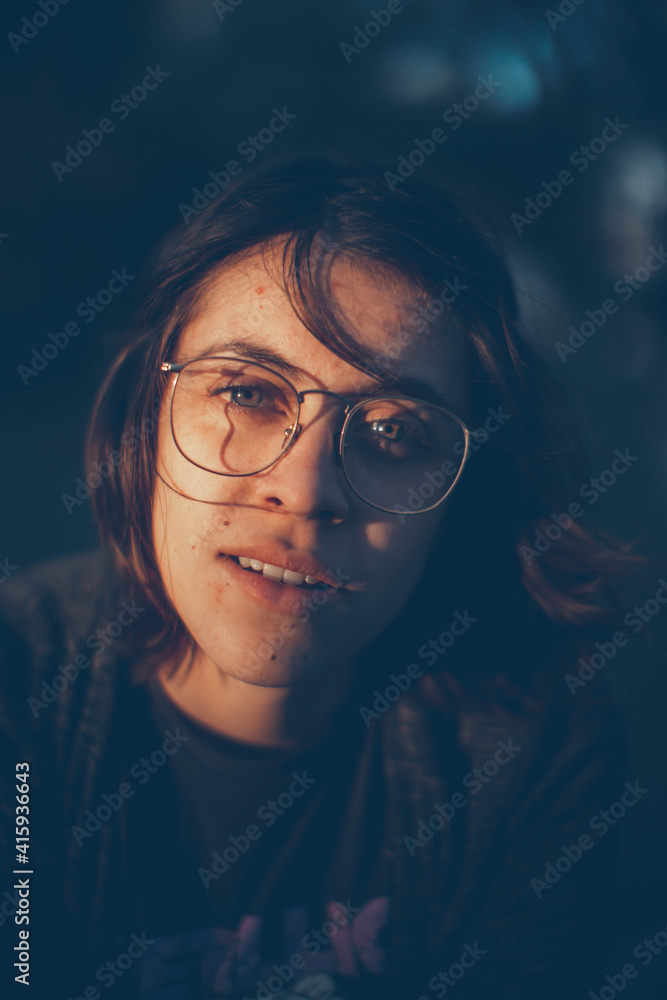 Glamorous brown-haired woman breathes on a window with water drops in neon light close-up. Glamorous brown-haired woman breathes on a window with water drops in neon light close-up.