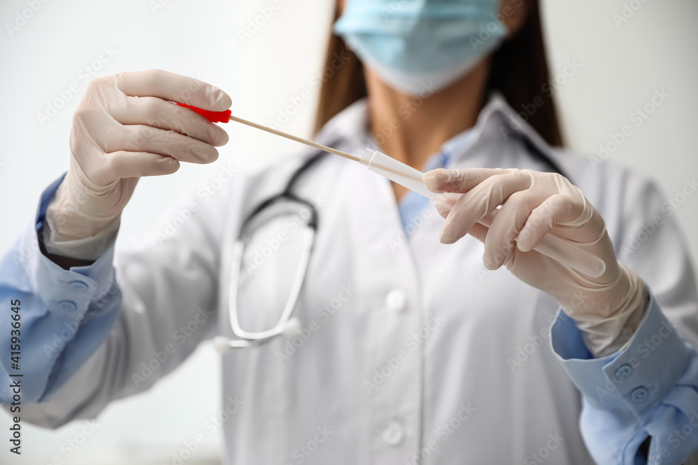Doctor holding buccal cotton swab and tube for DNA test in clinic, closeup Doctor holding buccal cotton swab and tube for DNA test in clinic, closeup