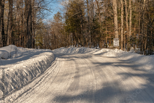 Plowed winter road with caution large trucks hauling signage