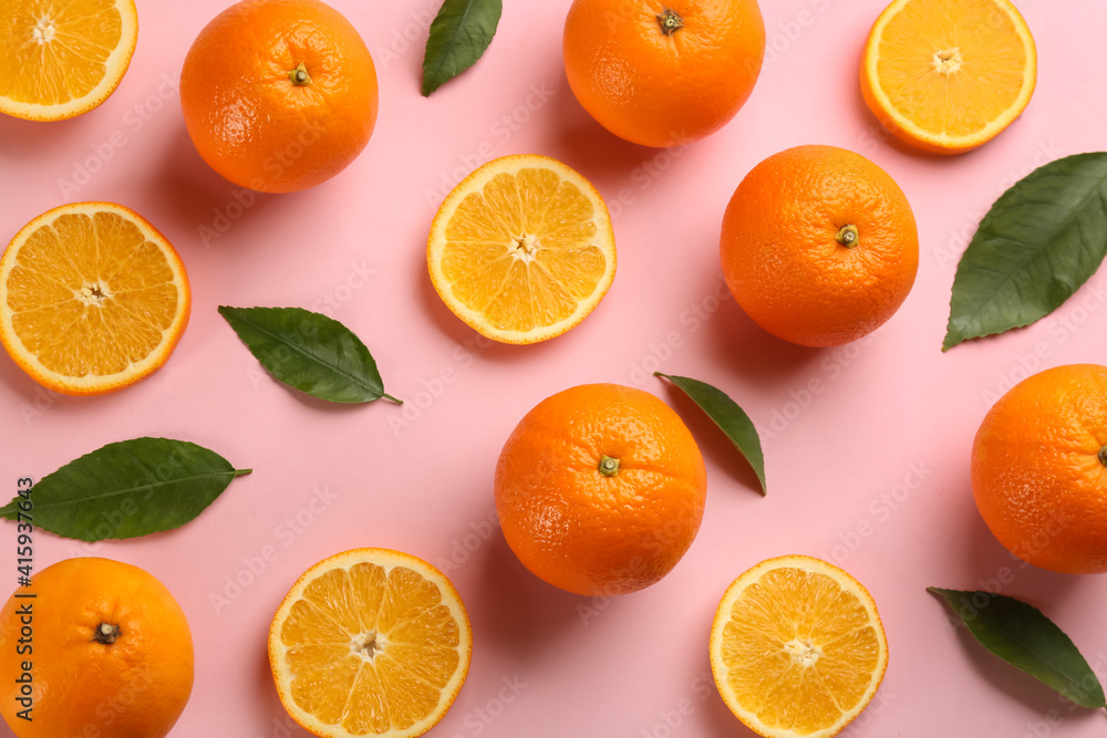 Fresh ripe oranges with green leaves on pink background, flat lay Fresh ripe oranges with green leaves on pink background, flat lay