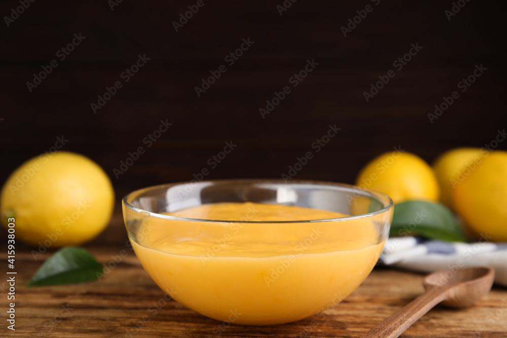 Delicious lemon curd in glass bowl on wooden table Delicious lemon curd in glass bowl on wooden table
