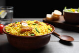 Delicious pilaf with chicken meat on wooden table