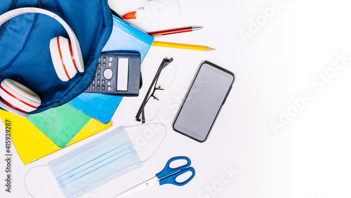 School supplies for school, notebooks, pens, scissors and a mask. photo