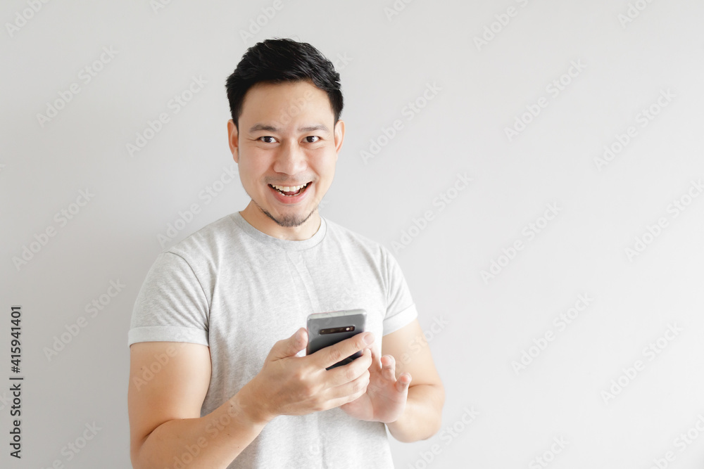 Asian man is feeling happy with the application in the smartphone. Asian man is feeling happy with the application in the smartphone.