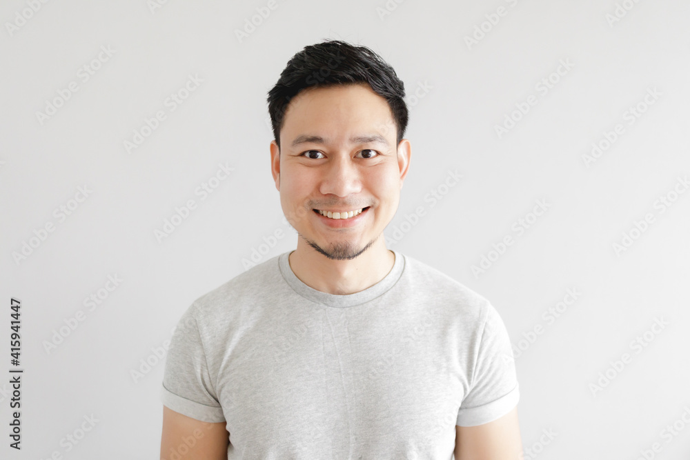 Smile face of happy Asian man wear grey t-shirt and on grey background. Smile face of happy Asian man wear grey t-shirt and on grey background.